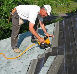 Man installing asphalt shingles on a roof