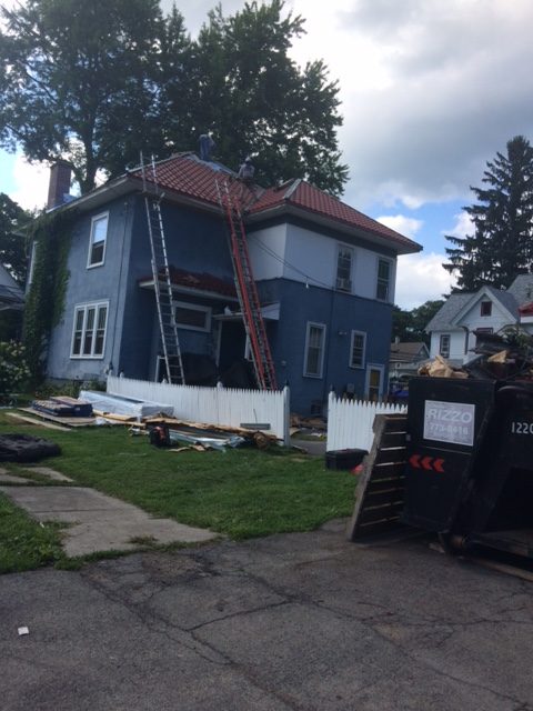 In-progress installation of a red metal roof