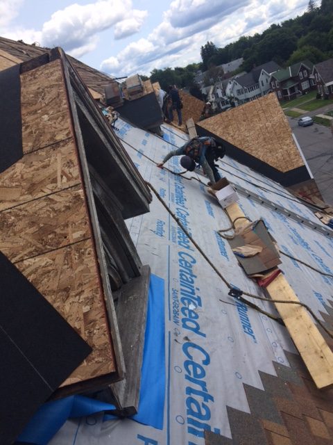 Men on a roof installing new shingles