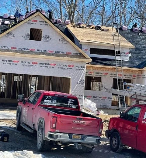 The Allen Roofing, LLC truck parked in front of a home construction site