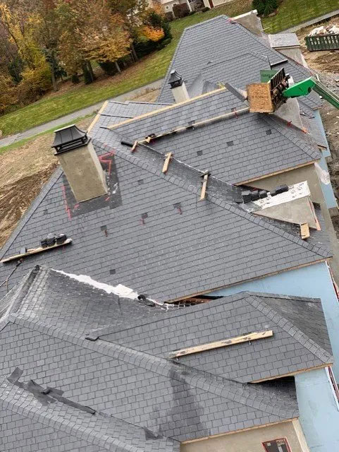 Aerial shot of a row of houses with grey shingle roofs